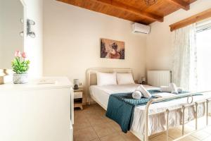 1 dormitorio con cama y ventana en Lovely Maisonette in the village en Márathos