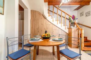 Márathos的住宿－Lovely Maisonette in the village，一间带木桌和蓝色椅子的用餐室