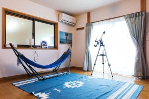 a tripod and a hammock in a room with a camera at ocean villa mint 満天の星空とオーシャンビューで心満たす一棟まるごと貸切別荘 南房総千倉 in Chikura