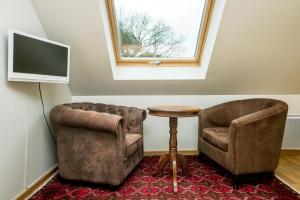 a living room with a chair and a table and a television at La Canopée des Pins in Cléder