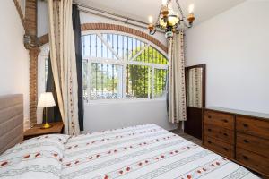 a bedroom with a large bed and a window at Villa Terrenito Private Pool by AORA STAY in Fuengirola