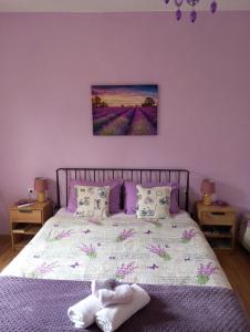 1 dormitorio con 1 cama con flores púrpuras en Apartman Lavanda, en Trebinje