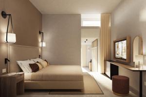 una camera con letto, specchio e TV di MClub Marmorata a Santa Teresa di Gallura