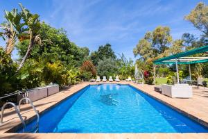 a swimming pool with blue water in a yard at Villa Terrenito Private Pool by AORA STAY in Fuengirola +38 photos