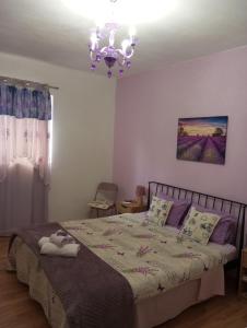 1 dormitorio con cama y lámpara de araña en Apartman Lavanda, en Trebinje