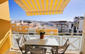 uma mesa e cadeiras numa varanda com vista em Garden Hill Relax & Old Town by OCvillas em Albufeira