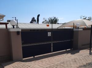 a building with a black garage door with a roof at Allegro Guest House in Prieska