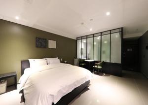 Schlafzimmer mit einem großen weißen Bett und einem Schreibtisch in der Unterkunft 3S Hotel Sorae in Incheon