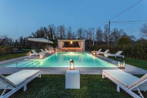 - une piscine avec 2 chaises longues dans l'établissement Villa Otto Luxury Tuscan Farmhouse with Pool, à Orentano