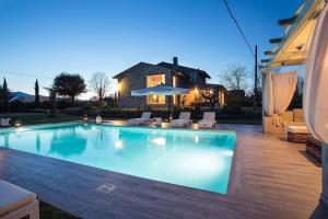 - une piscine avec des chaises et une maison dans l'établissement Villa Otto Luxury Tuscan Farmhouse with Pool, à Orentano