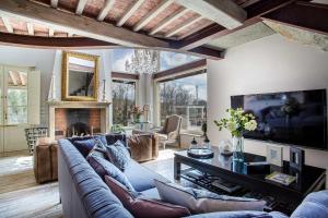 - un salon avec un canapé et une télévision dans l'établissement Villa Otto Luxury Tuscan Farmhouse with Pool, à Orentano