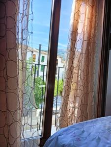 - une chambre avec une fenêtre donnant sur un balcon dans l'établissement La Casa de la Plaza, à Güéjar-Sierra