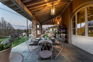 - un coin repas extérieur avec une table et des chaises sur la terrasse dans l'établissement Villa Otto Luxury Tuscan Farmhouse with Pool, à Orentano