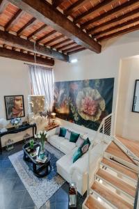 a living room with a white couch and a painting at CASA EDA, Modern Contemporary Central Apartment inside the Walls of Lucca in Lucca