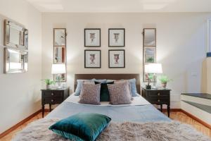 a bedroom with a bed with pillows and two lamps at CASA EDA, Modern Contemporary Central Apartment inside the Walls of Lucca in Lucca