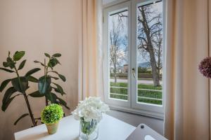 Habitación con ventana y mesa con flores en Casa Daria, Modern 4 Bedrooms Apartment in Lucca, en Lucca