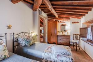 a bedroom with a bed and a dresser in a room at Le Bicocche Farmhouse: Country Stone Villa with Pool in Camaiore between Lucca & Beaches of Versilia in Montemagno +50 photos