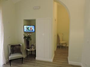 einen Flur mit einer Tür sowie einem Tisch und Stühlen in der Unterkunft Anfiteatro Suite in Rom