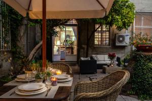 uma mesa exterior com cadeiras e um guarda-sol em Casa Al Giardino em Lucca