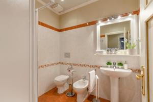 uma casa de banho com um lavatório, um WC e um espelho. em Casa Al Giardino em Lucca