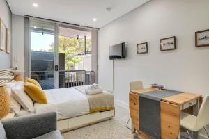 um quarto com uma cama, uma televisão e um sofá em Studio in Crown St - Private Balcony & Aircon em Sydney
