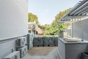 um pátio exterior com comodidades para churrascos ao ar livre e um edifício em Studio in Crown St - Private Balcony & Aircon em Sydney
