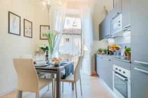 - une cuisine et une salle à manger avec une table et des chaises dans l'établissement CASA BRUMAR, the Most Central Terrace inside the Walls of Lucca, à Lucques