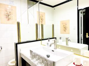 那覇市にあるOne Styleの白いバスルーム(洗面台2台、トイレ付)