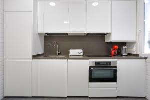 een witte keuken met witte kasten en een spoelbak bij VT Anboto by Bilbaohost in Bilbao