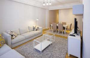 een woonkamer met een bank, een tv en een tafel bij VT Anboto by Bilbaohost in Bilbao