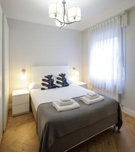 een slaapkamer met een bed met twee handdoeken erop bij VT Anboto by Bilbaohost in Bilbao