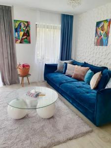 ボーヒニにあるLuxury Apartment near Lake Bohinjのリビングルーム(青いソファ、ガラスのテーブル付)