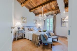 a bedroom with a bed and a table and chairs at La Vaseria Country House with Secret Garden and pool in Ghivizzano