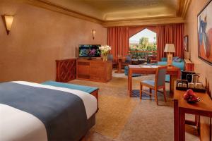 マラケシュにあるエ サーディ マラケシュ リゾート パレスのベッドとリビングルームが備わるホテルルームです。