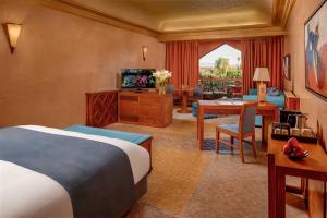 a hotel room with a bed and a living room at Es Saadi Marrakech Resort - Palace in Marrakech