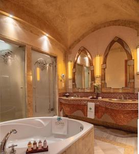 a large bathroom with a tub and two sinks at Es Saadi Marrakech Resort - Palace in Marrakech