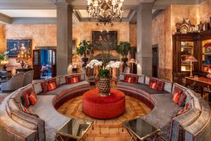 un vestíbulo con una mesa con un jarrón de flores en Helvetia&Bristol Firenze – Starhotels Collezione, en Florencia