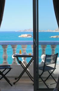 a table and chair on a balcony with a view of the ocean at Le Rhul in Marseille