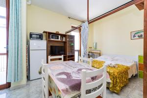 ガリポリにあるFive sea view apartments - by Click Salentoのベッドルーム1室(ベッド2台付)、キッチン(冷蔵庫付)