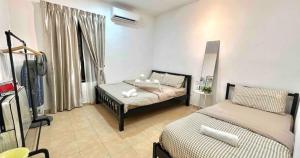A'Famosa Bungalow*Private Garden Stage*22Pax*NEW في Kampong Ulu Pegoh: غرفة نوم بسريرين ومغسلة فيها +55 صورة