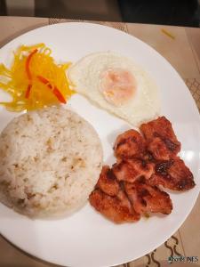 a white plate of food with rice and an egg at Dapdap ShoreLINES Beach House in San Francisco