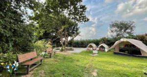 A'Famosa Bungalow*Private Garden Stage*22Pax*NEW في Kampong Ulu Pegoh: حديقة فيها خيمة ومقعد على العشب