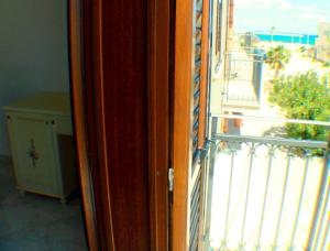 Une porte ouverte s'ouvre sur un balcon avec vue. dans l'établissement Araba Fenice Hotel, à San Vito Lo Capo