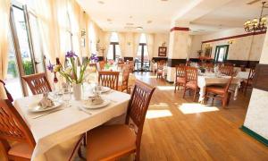 uma sala de jantar com mesas e cadeiras num restaurante em Hotel Ana em Arad