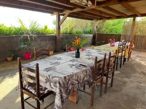 een lange tafel met houten stoelen in een patio bij La Villa Soleil in Trois Bassins