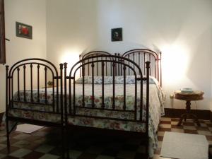 a bedroom with a metal bed with flowers on it at Azienda Agrituristica Tenuta Pizzolungo in Erice