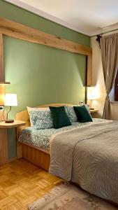 a bedroom with a large bed with green walls at Guesthouse Sabine - pr` Skminc in Bohinjska Bela