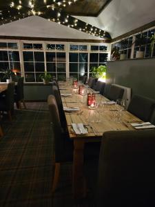 una larga mesa de madera en un restaurante con luces en The Pack Horse Inn en Ellingham