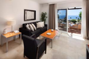een woonkamer met een bank en een tafel bij Mijas Costa Blue Sky Sea Views by ALFRESCO STAYS in Mijas Costa