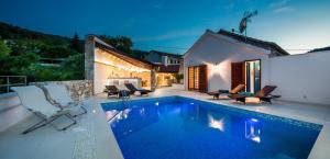 una piscina con sillas y una casa en Villa Jasmine, en Dol
